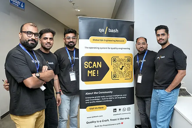 QA Bash team beside the community banner